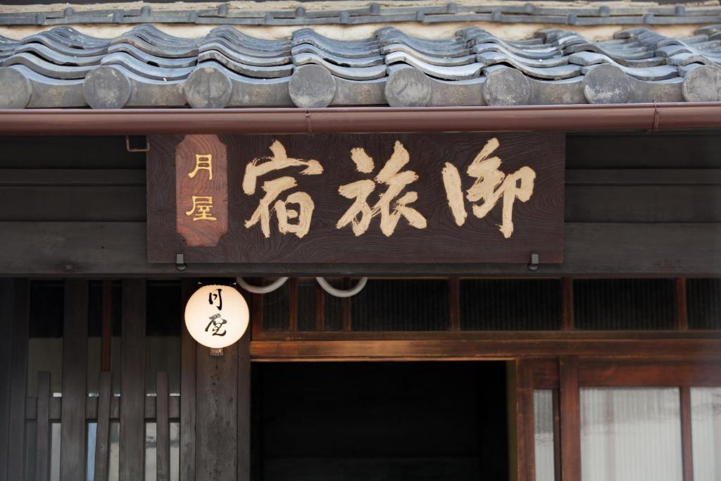 a sign on a building with chinese writing on it at Bed & Breakfast Tsukiya in Kyoto
