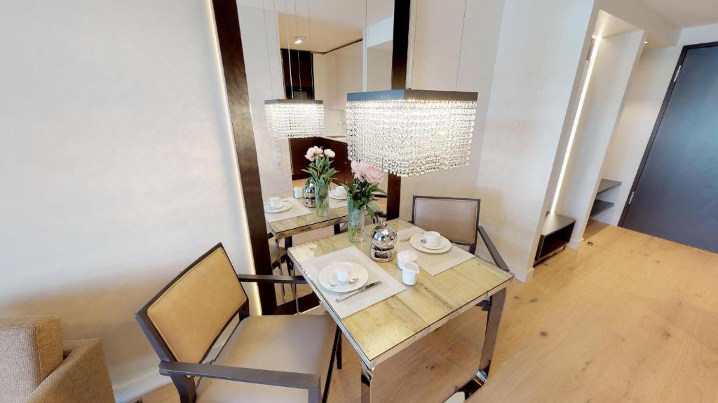 a dining room with a table and chairs and a chandelier at White Pearl Apartment 2.15 in Timmendorfer Strand
