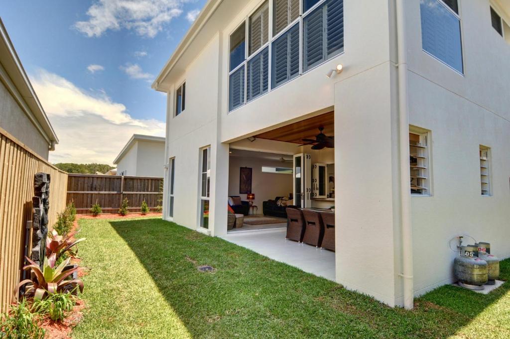 a white house with a patio and grass at Coolum Street 41 Dicky Beach in Caloundra