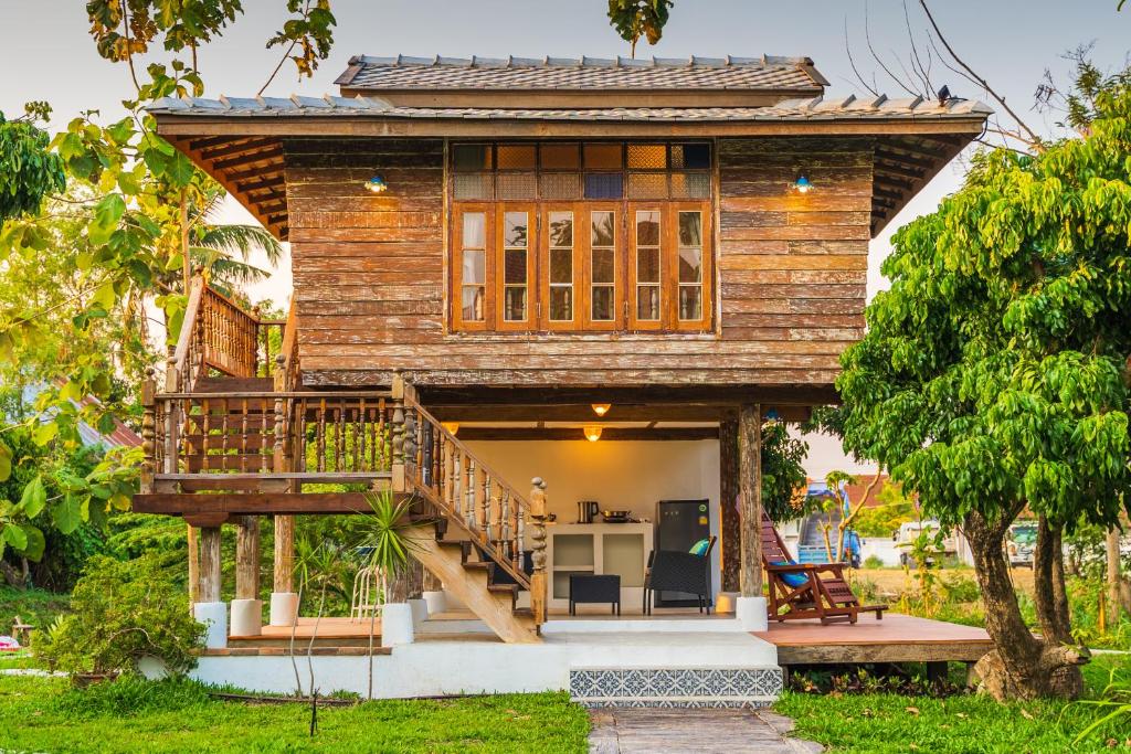 a small house with a deck and a table at baanchandra in Chiang Mai