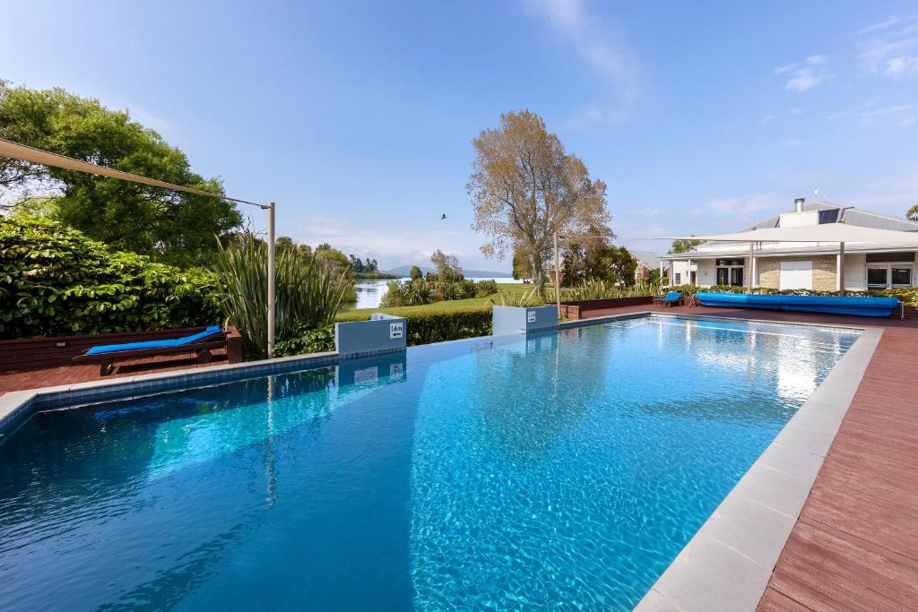 a swimming pool with blue water in a house at Ramada Resort By Wyndham Rotorua Marama in Rotorua