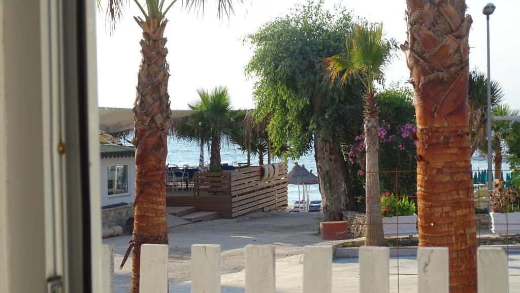 een groep palmbomen en een wit hek bij Seaside Cabin Ksamil in Ksamil