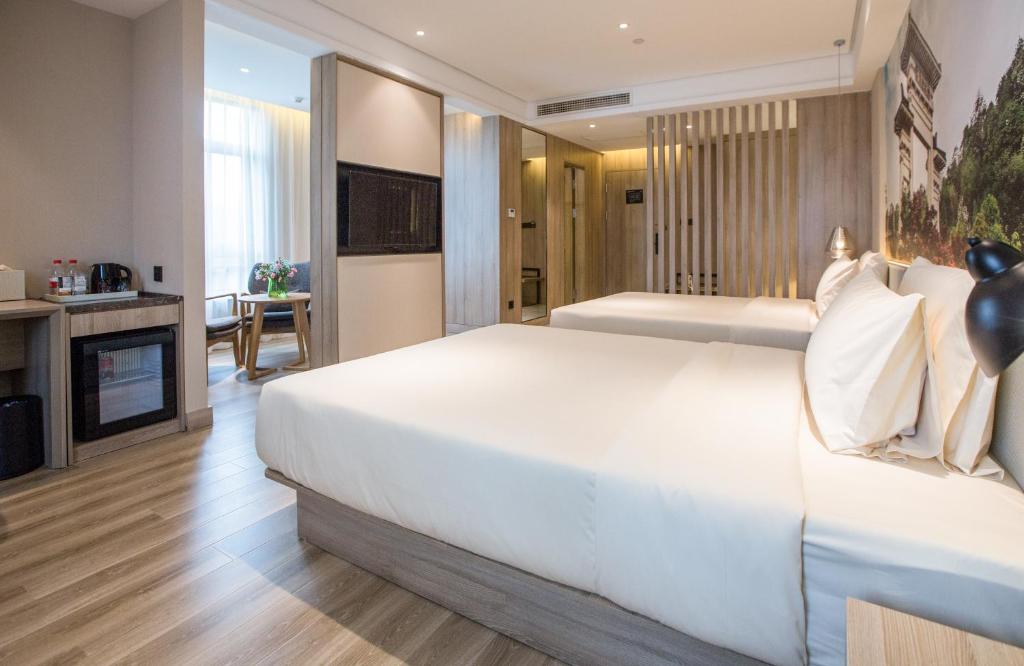 a bedroom with a large white bed and a fireplace at Atour Hotel Zhenjiang Nanxu Avenue Branch in Zhenjiang