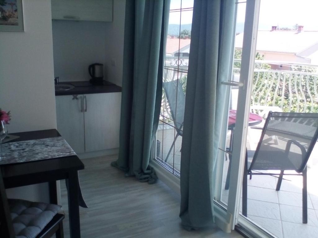 a living room with a door open to a balcony at Ana Rooms in Krk