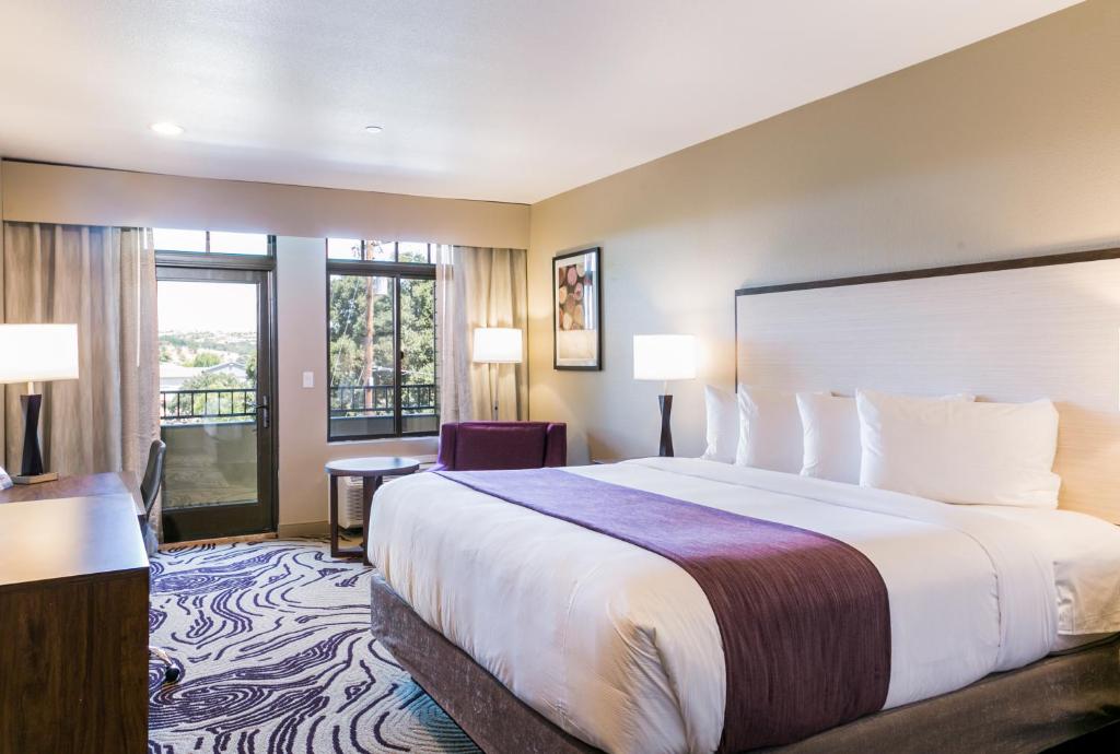 a hotel room with a large bed and a balcony at Hotel Siri Downtown - Paso Robles in Paso Robles