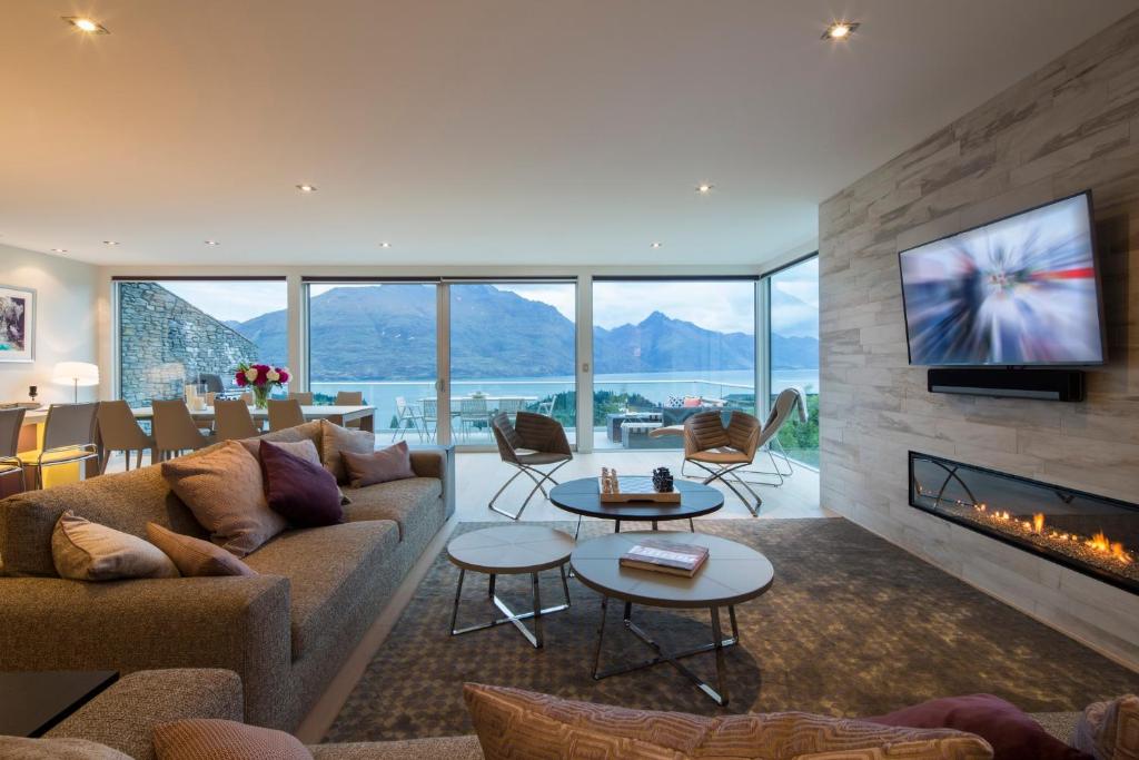 a living room with a couch and a fireplace at Papillon, a Relax it's Done luxury holiday home in Queenstown
