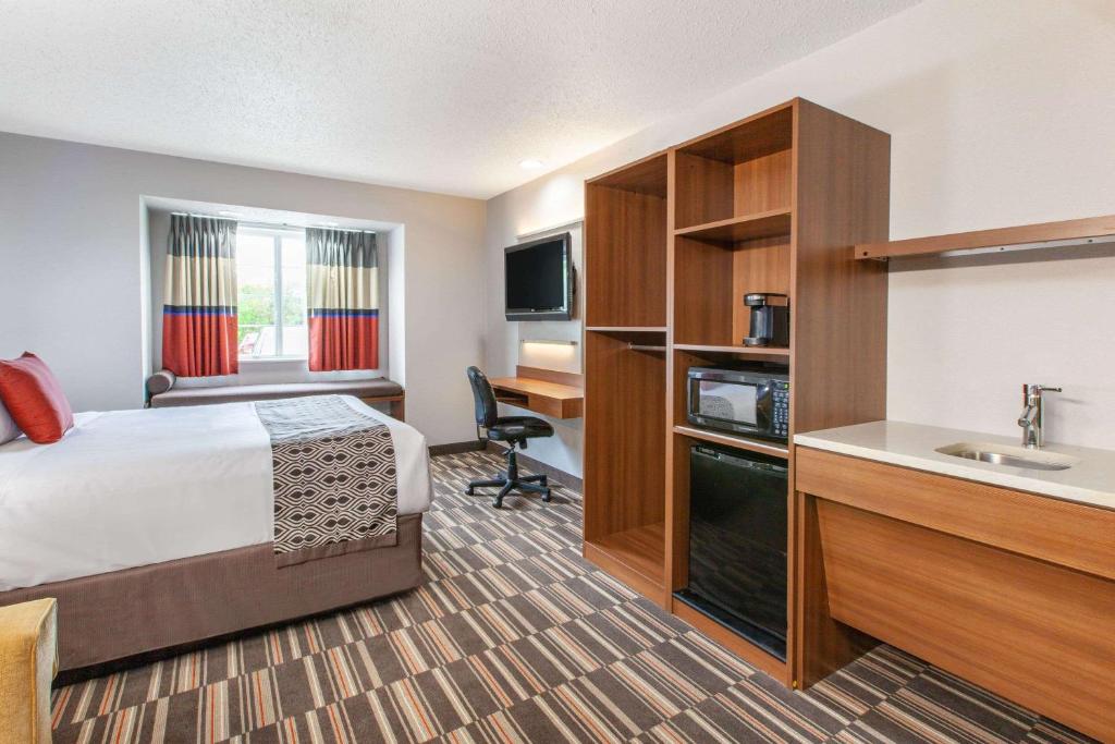 Cette chambre comprend un lit et un lavabo. dans l'établissement Microtel Inn & Suites by Wyndham Pittsburgh Airport, à Robinson Township