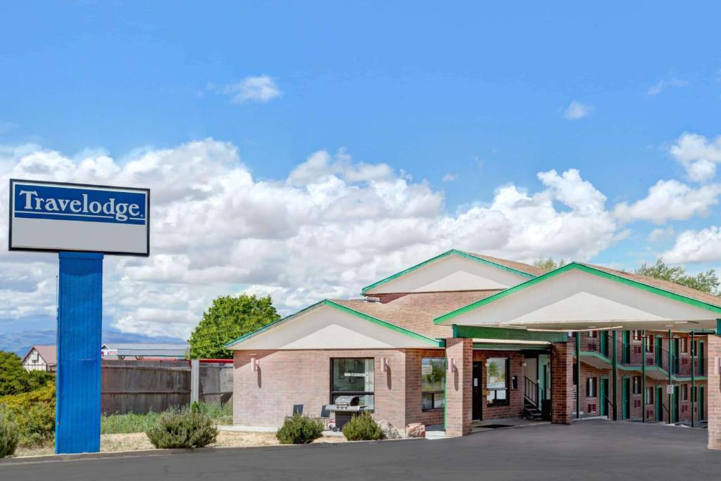 a hotel with a sign in front of a building at Travelodge by Wyndham Cedar City in Cedar City