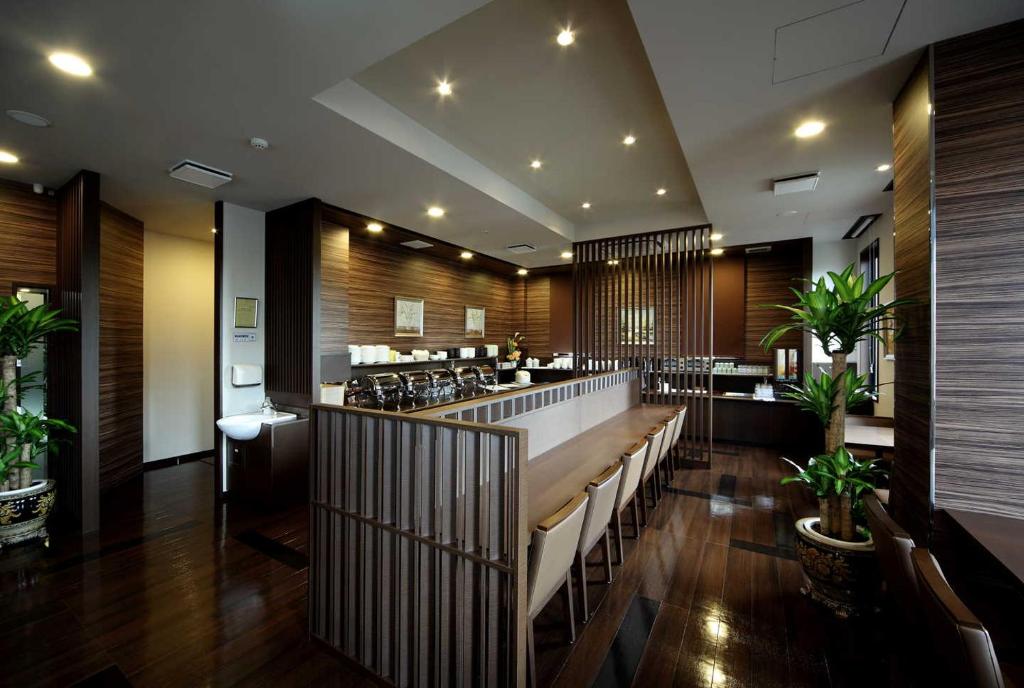 新潟市にあるホテルルートイン新潟西インターのベンチと植物のあるバー付きのレストラン