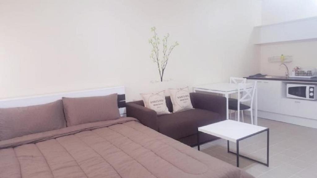 a living room with a couch and a table at Condo C4 IMPACT in Nonthaburi