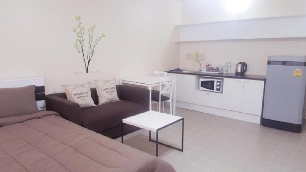 a living room with a couch and a kitchen at Popular Condo C4 in Nonthaburi