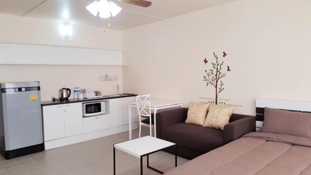 a living room with a couch and a kitchen at Popular Condo P1 in Nonthaburi