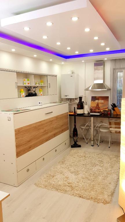 une cuisine avec des placards blancs et une table avec un tapis dans l'établissement Luxury Paul apartment green, private & accessible, à Braşov