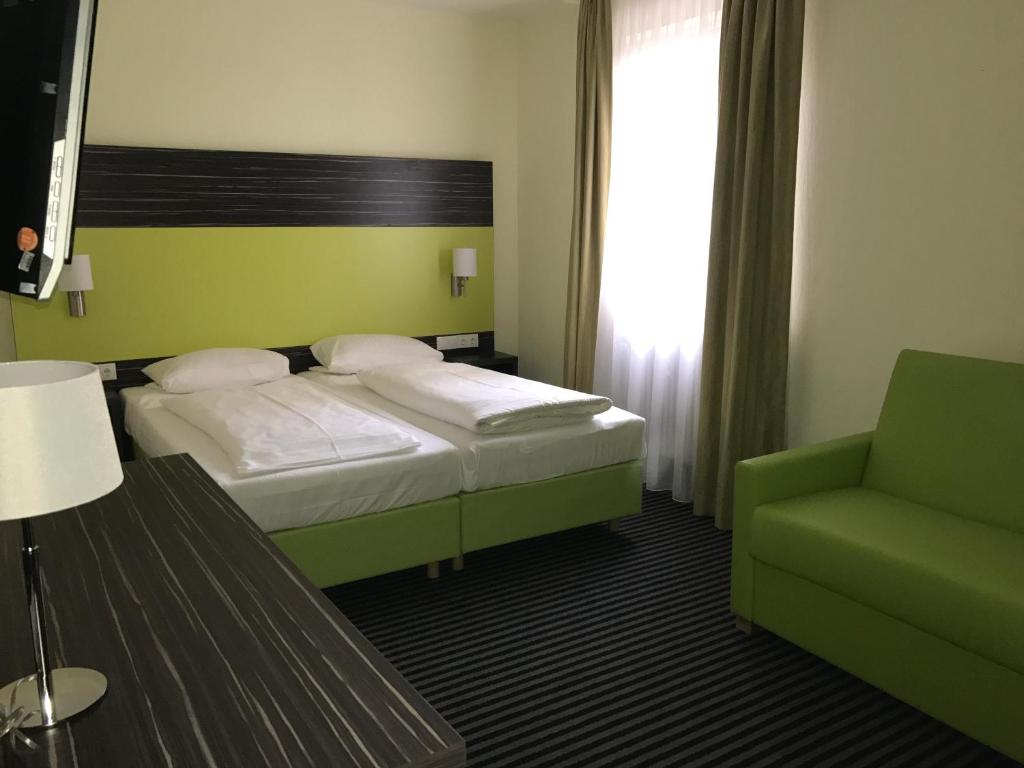Postel nebo postele na pokoji v ubytování Behringers City Hotel Nürnberg