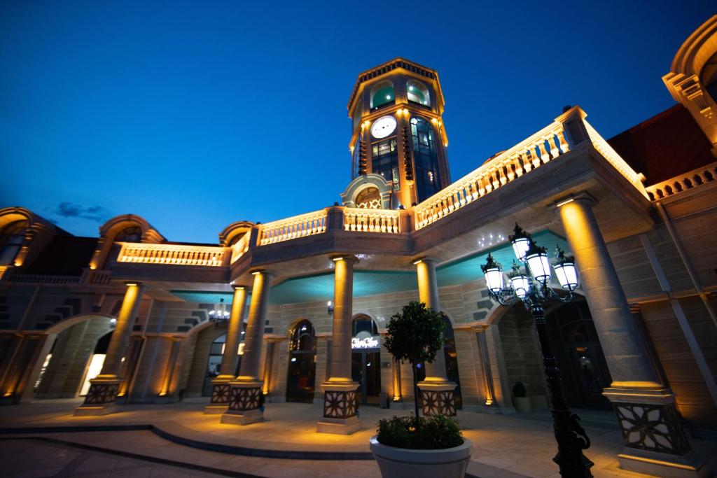 a large building with a clock tower in front of it at Saat Meydani Nakhchivan in Naxçıvan