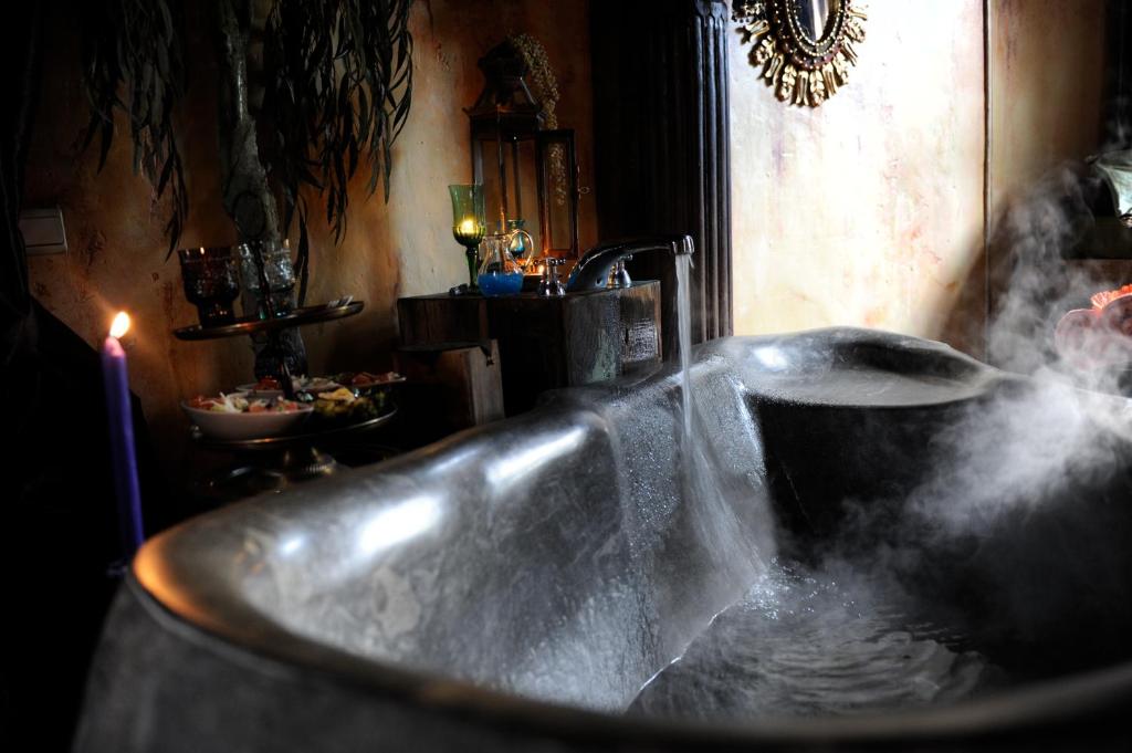 a bath tub with steam coming out of it at B&B Le Manoir d'Ange in Ferrières