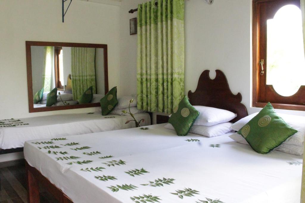 2 łóżka pojedyncze w pokoju z lustrem w obiekcie Hideaway Homestay Habarana w mieście Habarana