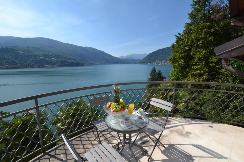 a table on a balcony with a view of a lake at Villa Rina Deluxe and Cottage in Porto Ceresio