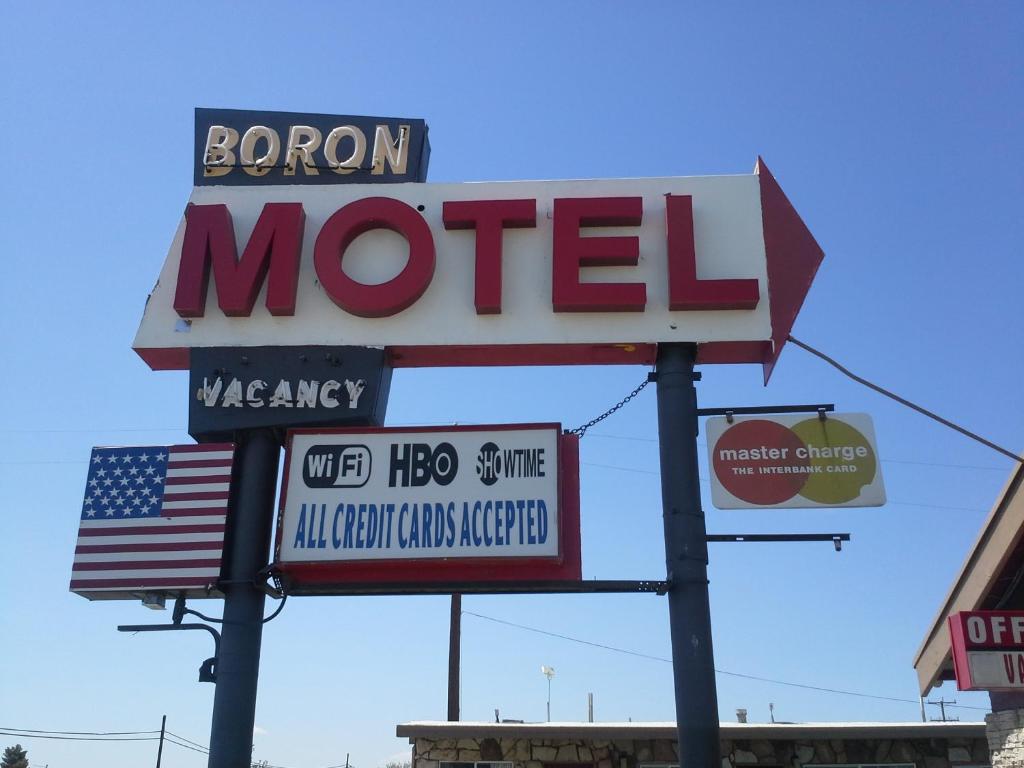 Una señal para un motel con bandera americana en Boron Motel, en Boron