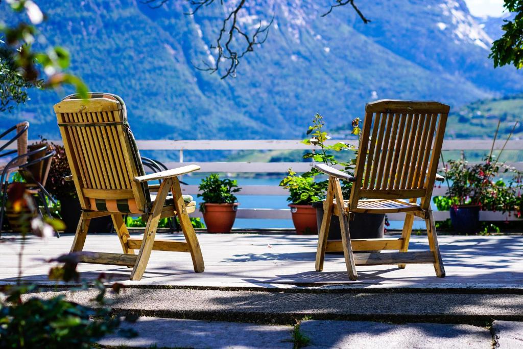 two chairs sitting on a patio with mountains in the background at Fjord House in Grimo