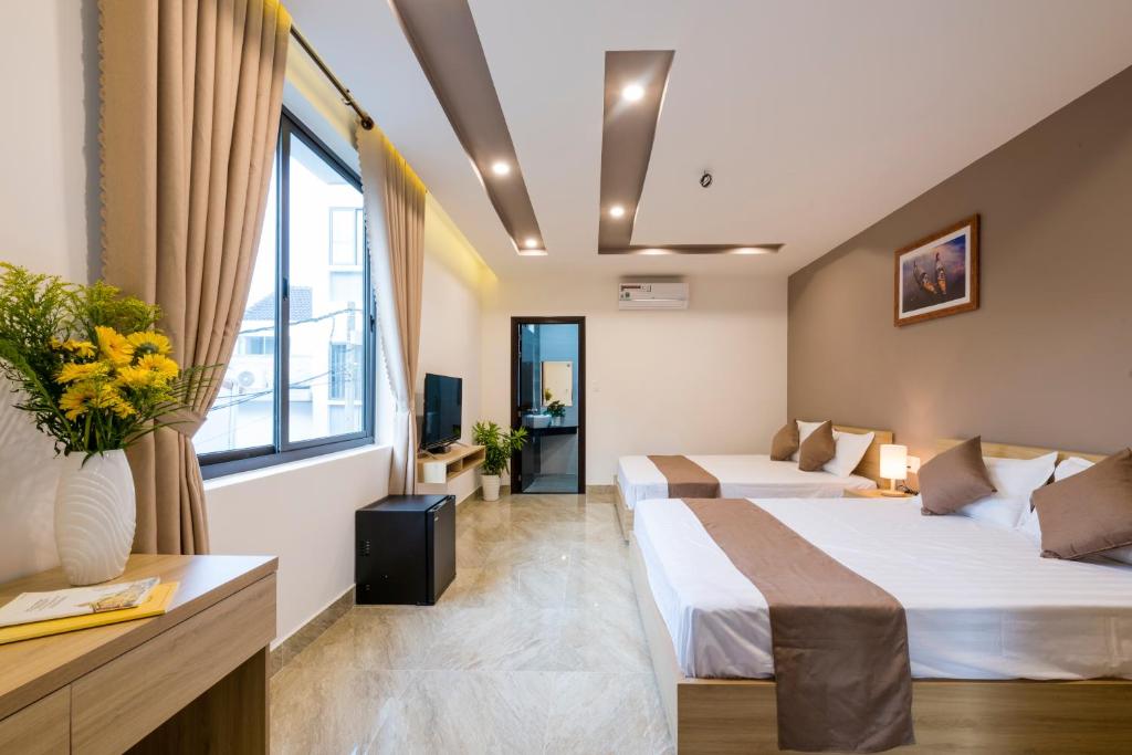 une chambre d'hôtel avec deux lits et une fenêtre dans l'établissement Hoài River Hội An Homestay Sông Hoài Homestay 250m walk to the center Old Town, à Hội An