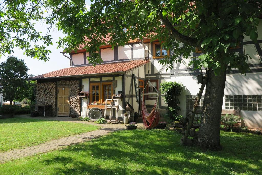 una casa con un árbol en el patio en Fachwerktraum im Hof, en Alheim