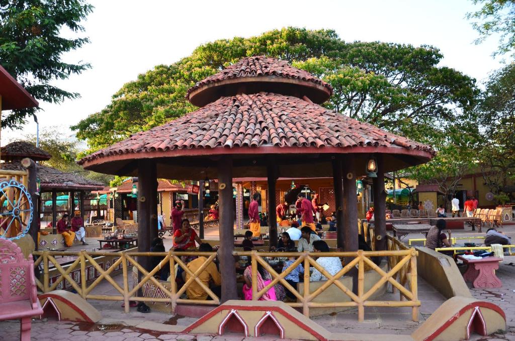 a gazebo in a park with people sitting at tables at Nakhrali Dhani Resort in Indore