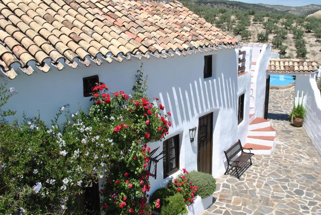 een wit huis met bloemen op een patio bij Casa Miguel Montefrio in Granada