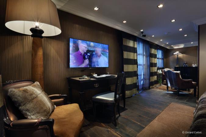 a living room with a tv on a wall at Hotel Le Saint Roch in Courchevel