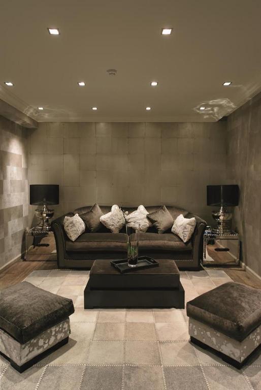 a living room with a couch and two ottomans at Hotel Le Saint Roch in Courchevel