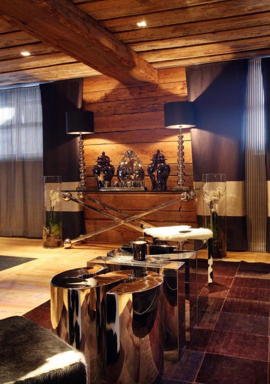 a living room with a table and some chairs at Hotel Le Saint Roch in Courchevel