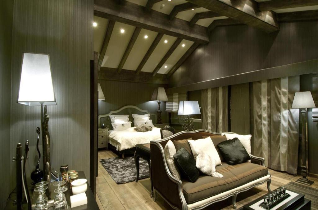 a living room with a couch and a bed at Hotel Le Saint Roch in Courchevel