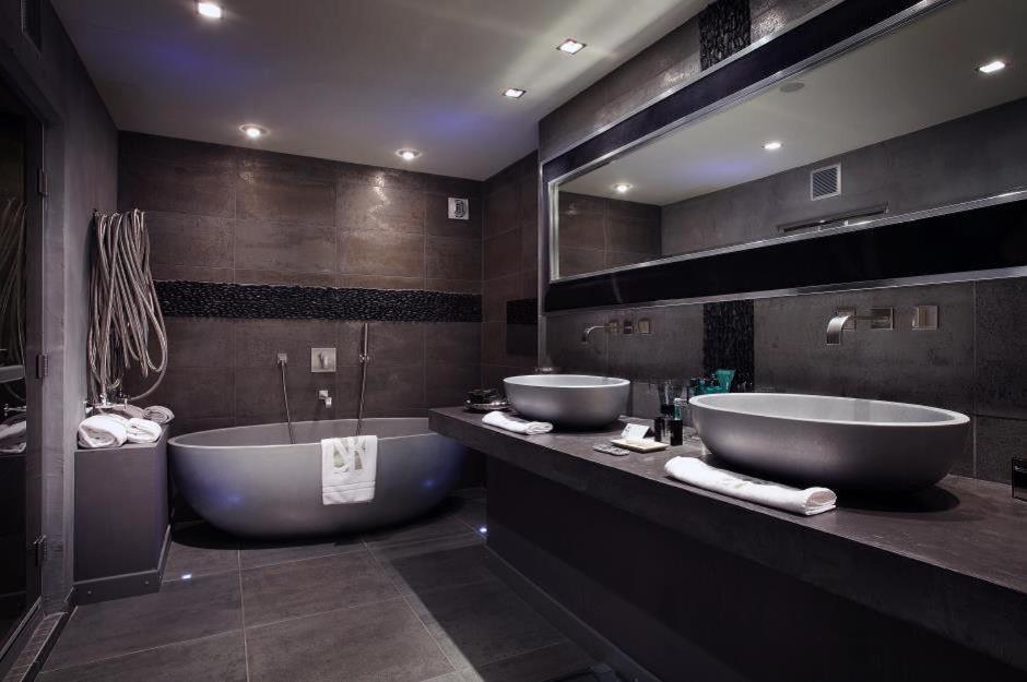 a large bathroom with two sinks and a tub at Hotel Le Saint Roch in Courchevel