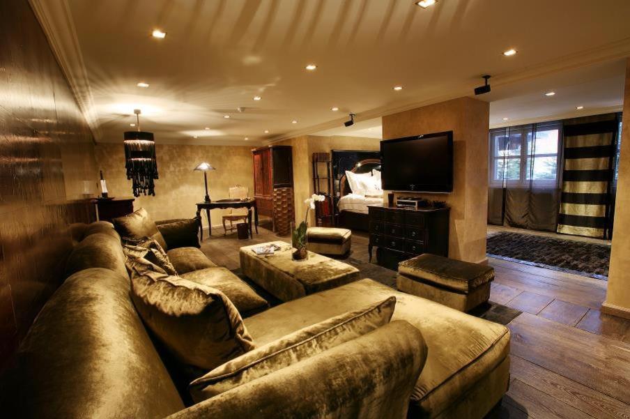 a large living room with a couch and a television at Hotel Le Saint Roch in Courchevel