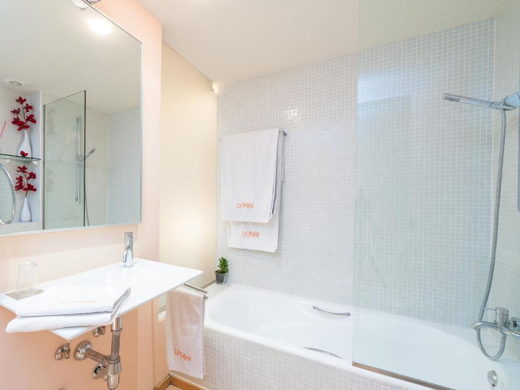a bathroom with a tub and a sink and a shower at Cas Ferrer Nou Hotelet in Alcudia
