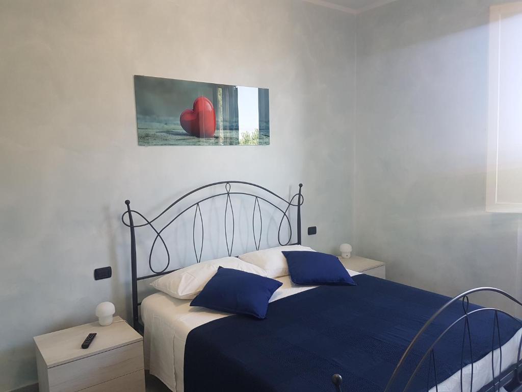 a bedroom with a bed with blue sheets and a picture on the wall at Piccolo Poggio Apartments in Florence