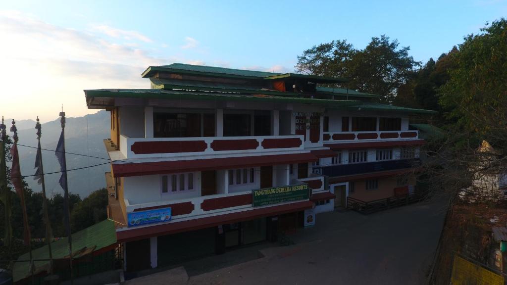 een gebouw aan de zijkant van een berg bij Yangthang Dzimkha Resort in Pelling