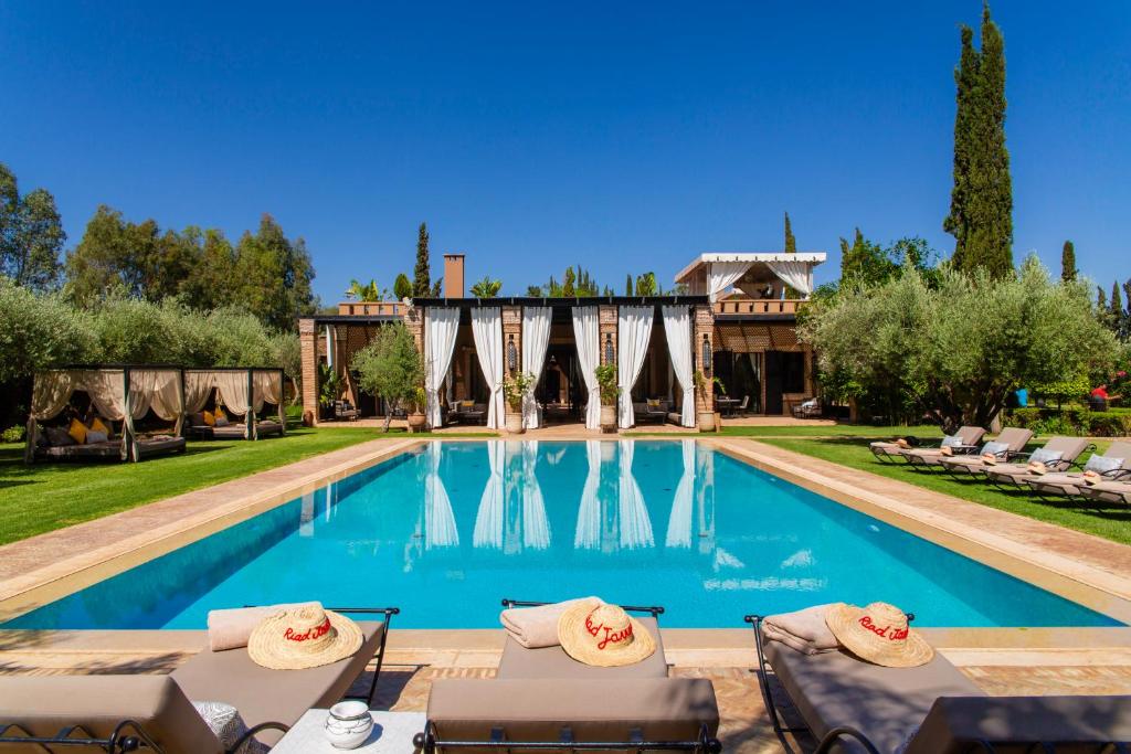 una piscina con sillas y una casa en Riad Jawad & Spa, en Marrakech