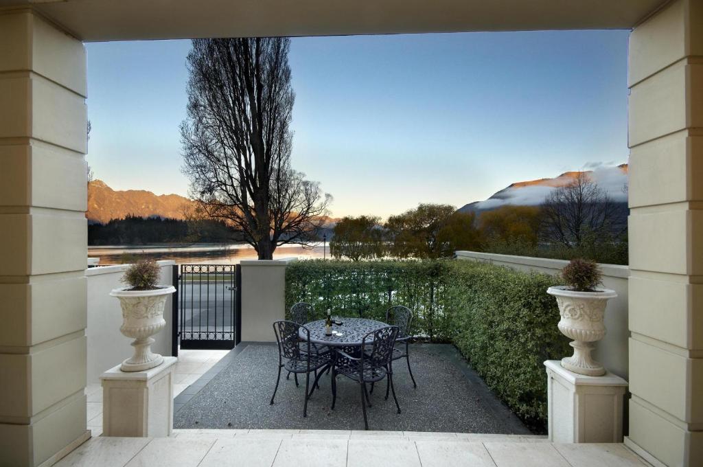 a patio with a table and chairs on a balcony at Esplanade Queenstown by Staysouth in Queenstown