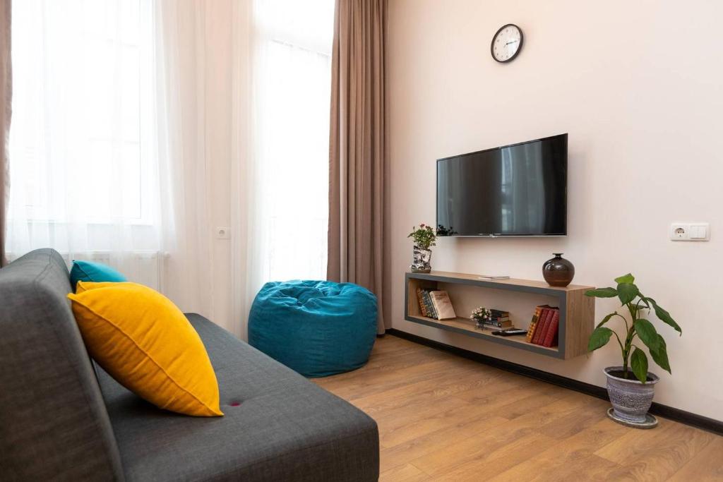 ein Wohnzimmer mit einem Sofa und einem Flachbild-TV in der Unterkunft Wehost Apartment for 3 in Tbilisi City