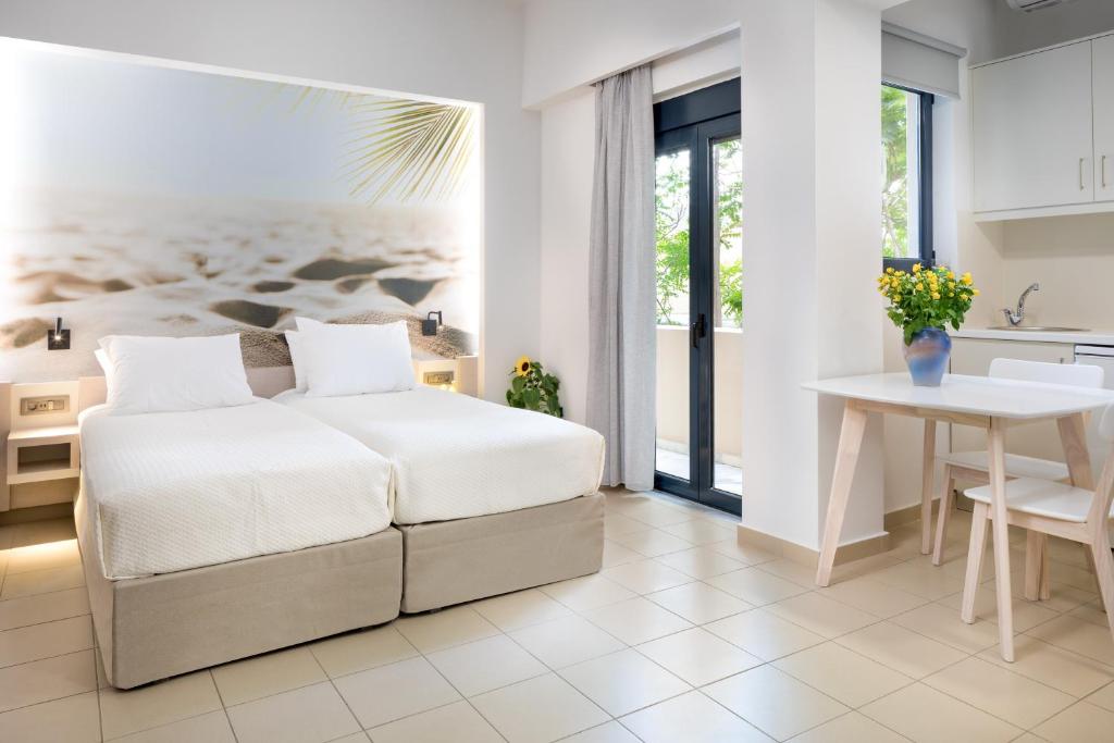 1 dormitorio con cama, mesa y cocina en Forum City Apartments, en La Canea