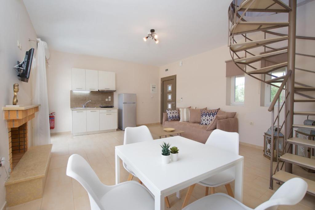 a kitchen and living room with a white table and chairs at Rose Maisonette in Kefallonia