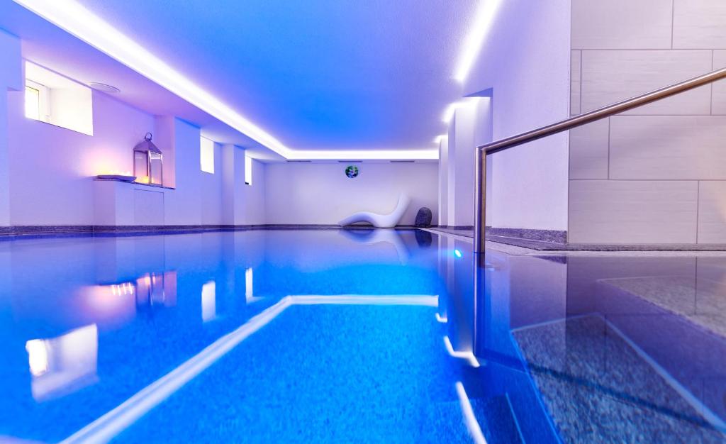 a swimming pool in a room with a swimming pool at Auenwald Hotel und Apartmenthaus in Leipzig