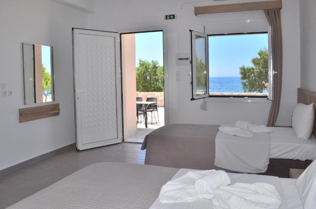 een slaapkamer met 2 bedden en uitzicht op de oceaan bij Votsalo Studios & Apartment in Frangokastello
