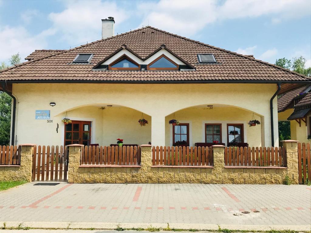 ein Haus mit einem Holzzaun davor in der Unterkunft Penzion Bělidlo in Königseck