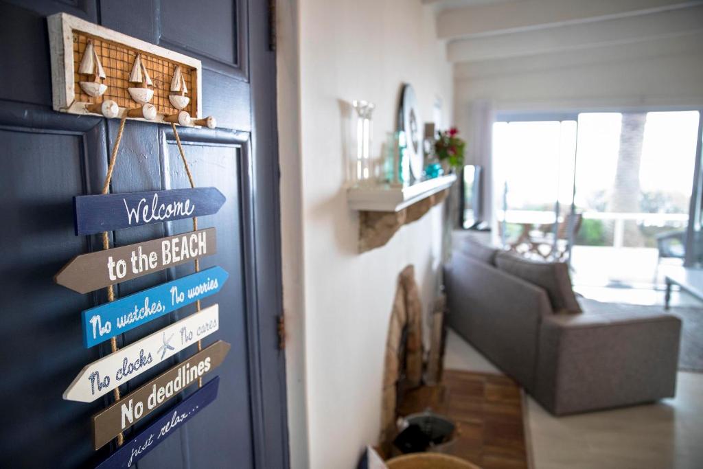 a living room with a blue door with signs on it at Palm Villa Cottage in Kommetjie