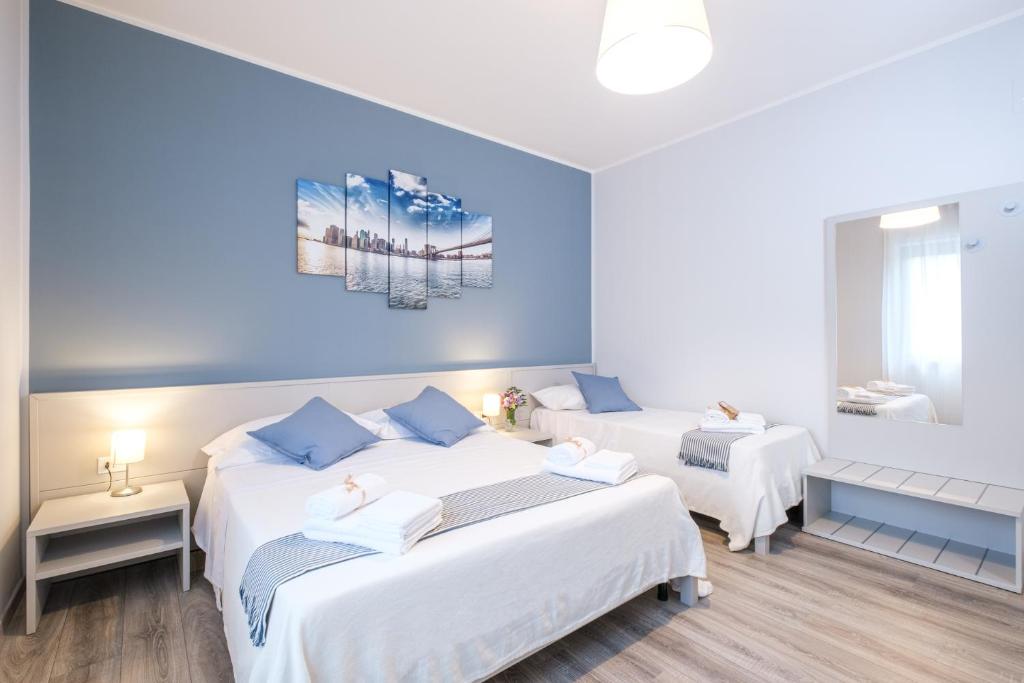 two beds in a room with blue walls at HOME52 in Rende
