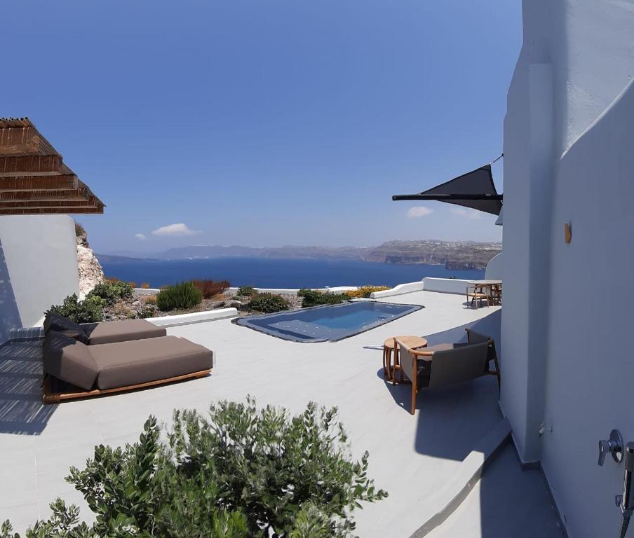 une terrasse avec des chaises et une piscine dans une maison dans l'établissement Avatar Suites, à Akrotiri