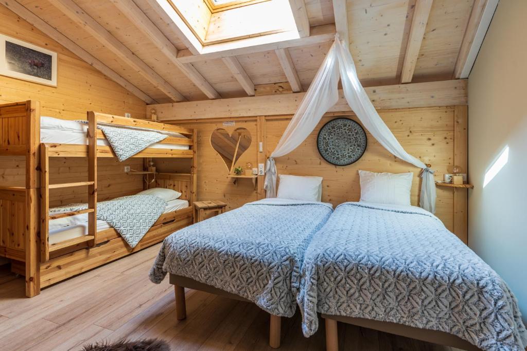 a bedroom with two beds in a log cabin at Domaine du Hirtz, Restaurant &amp; Spa in Wattwiller