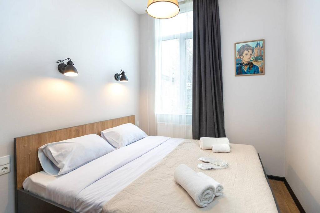 1 dormitorio con 1 cama con 2 toallas en Wehost Apartment With 3 Bedrooms, en Tiflis